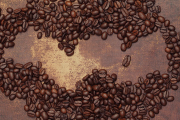 Dark brown roasted coffee beans on a shabby chic surface