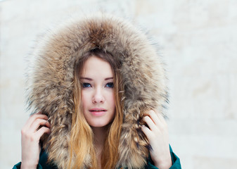 Winter portrait of beautiful girl in fur close-up. Toned in warm colors.