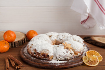 Christmas stollen and spices on wooden background