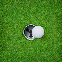 Golf ball and golf hole on green grass of golf course.