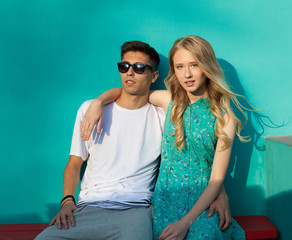 Beautiful young couple sitting on the bench on a warm summer evening.  Hispanic man, Caucasian girl