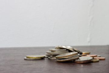 Pile of coin on wooden table with blurry background