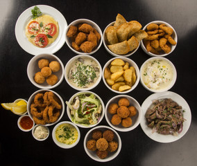 Mixed brazilian snacks, including pastries, fried chicken, salad
