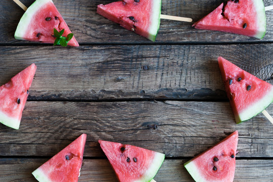 slices of watermelon on a dark wooden background