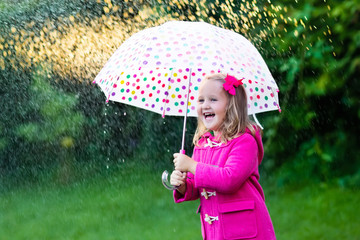 Little girl with umbrella in the rain