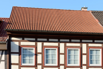 Fassade eines Fachwerkhauses mit weißen Fenstern vor blauem Himmel in Dransfeld, Niedersachsen, Deutschland