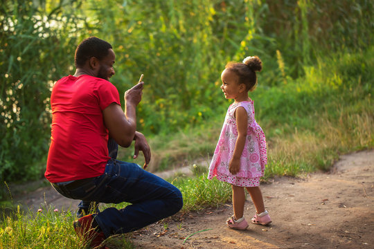 Black African father takes photo of his daughter