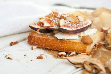 Bruschetta with goat cheese and figs on list of parchment