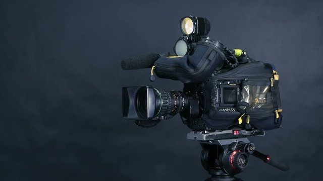 Movement along professional studio camera, camcoder standing in TV studio ready for broadcasting. 4K.