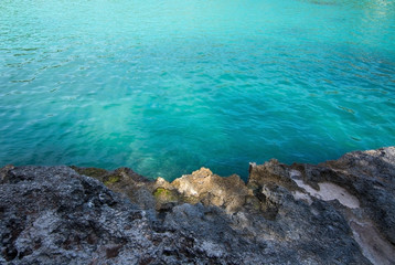 Rock and clear turquoise water background