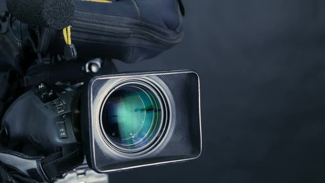 Movement along professional studio camera, camcoder standing in TV studio ready for broadcasting. 4K.