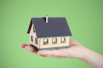 Hand holding house miniature. Home finance concept