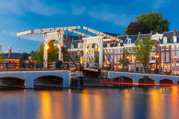 Fototapeta premium Magere Brug, Skinny bridge, with night lighting over the river Amstel in the city centre of Amsterdam, Holland, Netherlands