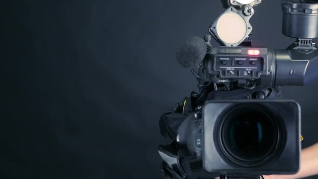Professional digital video camera, cacoder isolated on black background in tv srudio. 4K.
