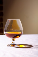 The glare from the glass of French brandy reflected on white tab