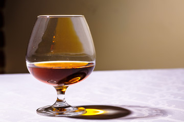 The glare from the glass of French brandy reflected on white tab
