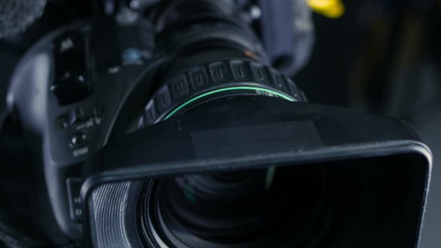 Movement along professional studio camera, camcoder standing in TV studio ready for broadcasting. 4K.