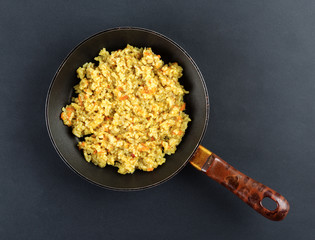 Boiled rice in a frying pan on a black