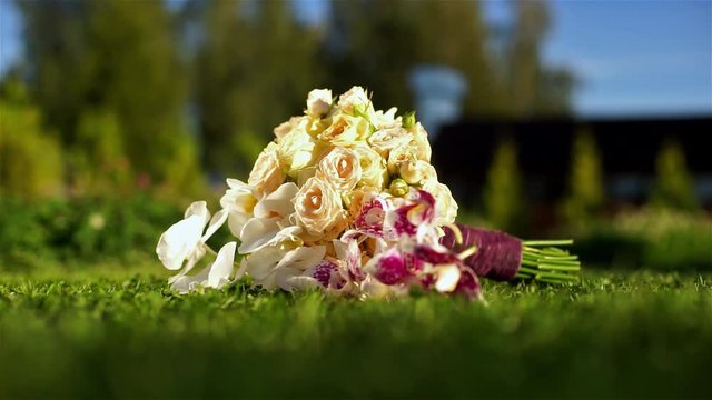 The bride's bouquet of white roses and berries on a green grass.