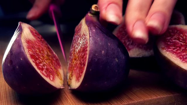 Woman cutting ripe fig 4K close up shot