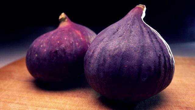 Whole ripe figs on cutting board. 4K close up pan shot