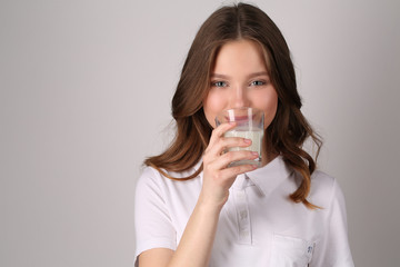 Girl tasting milk. Close up. White background