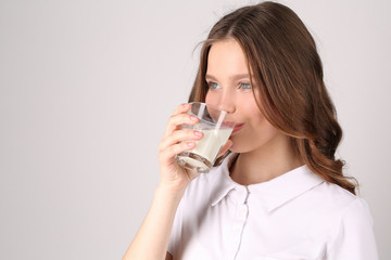 Lady in polo drinking milk. Close up. White background