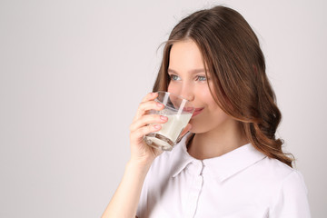 Model in T-shirt drinking milk. Close up. White background