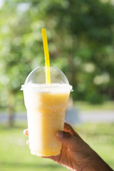 fresh pineapple smoothie in plastic glass