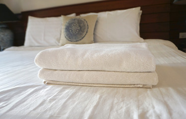 Fototapeta na wymiar White towels on white bedsheet