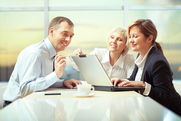 Business people discussing during a meeting and using laptop