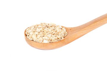 Oats flakes pile in wood spoon on white background