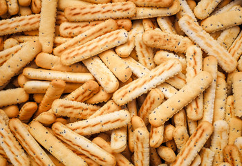 Bread sticks with poppy seeds as background