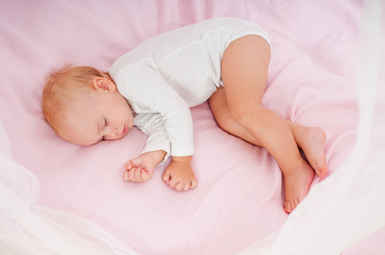 Beautiful sleeping baby. Peaceful baby lying on a bed in a brigh