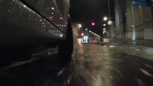 extremely low camera angle on the car on a rainy night