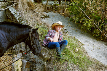 Boy posing with a horse after the workout . Ranch