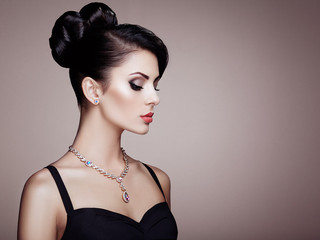 Fototapeta premium Fashion portrait of young beautiful woman with jewelry and elegant hairstyle. Brunette girl. Perfect make-up. Beauty style woman with diamond accessories