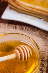 Fresh honey with a Stack of blinis or crepes