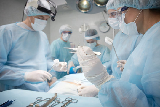 Team of professional surgeons working together in operating room