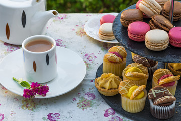 Tea with cakes and macaroons set up in the garden