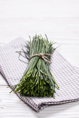 bunch of fresh chives on a wooden cutting board, selective focus