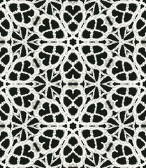 Black and white monochrome seamless pattern background made of repeating scanned elements of handmade crochet lace