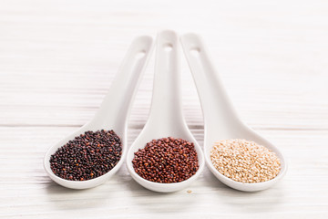 Red, black and white quinoa seeds on a wooden background,healthy food.