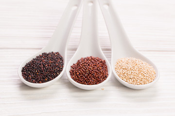 Red, black and white quinoa seeds on a wooden background,healthy food.