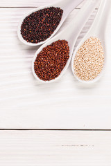 Red, black and white quinoa seeds on a wooden background,healthy food.