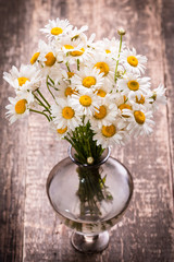 beautiful bouquet of chamomile on vintage wooden table