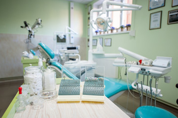 Close-up of set of different dental burs, polishing heads on the stand near dental chair in a modern stomatological office