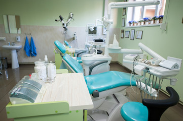 Dentist chairs with modern equipment at bright treatment room in dental practice