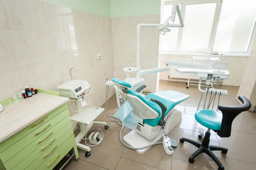 Dental clinic interior design with chair and tools. Dental chair, equipment and other accessories used by dentists in blue, medic light