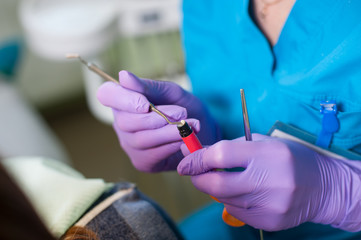 Close-up of doctor holding a composite cements for the treatment of the patient's tooth